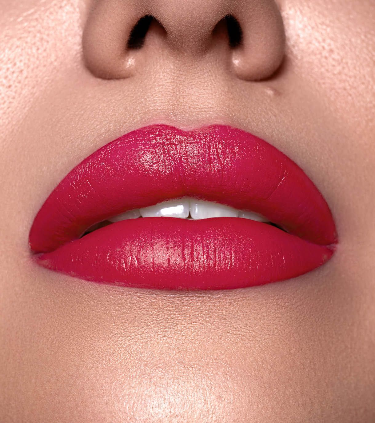 Primo piano di labbra carnose con rossetto rosso vivo e denti bianchi.