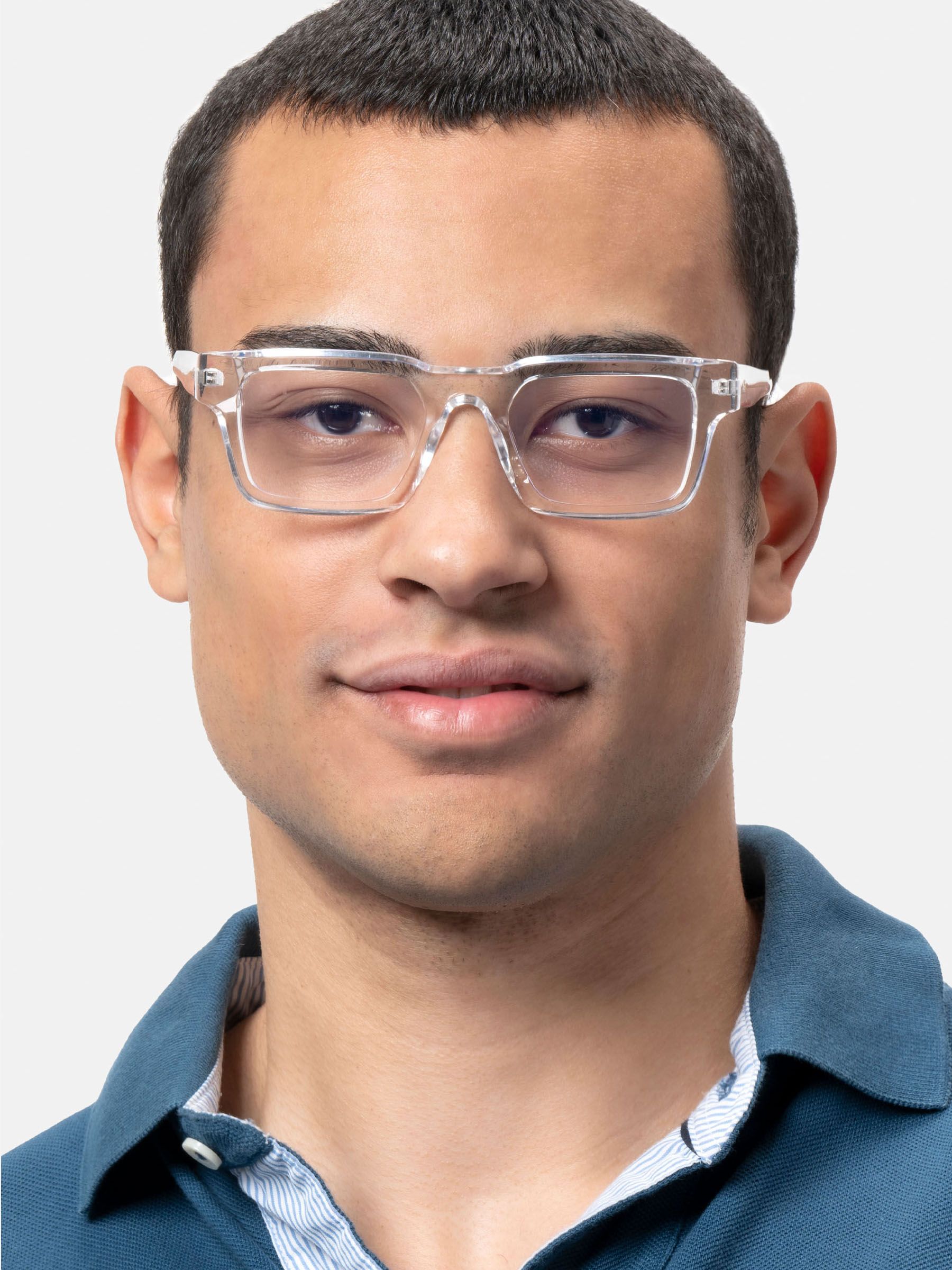 Uomo con camicia blu che indossa occhiali trasparenti.