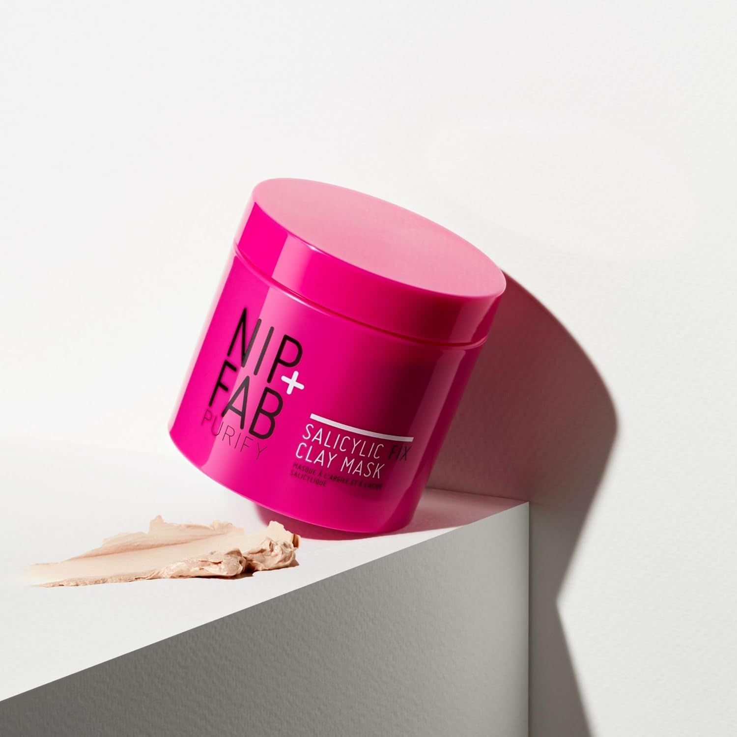 Vaso rosa Nip + Fab Salicylic Acid Fix Clay Mask. Prodotto e maschera su sfondo bianco.