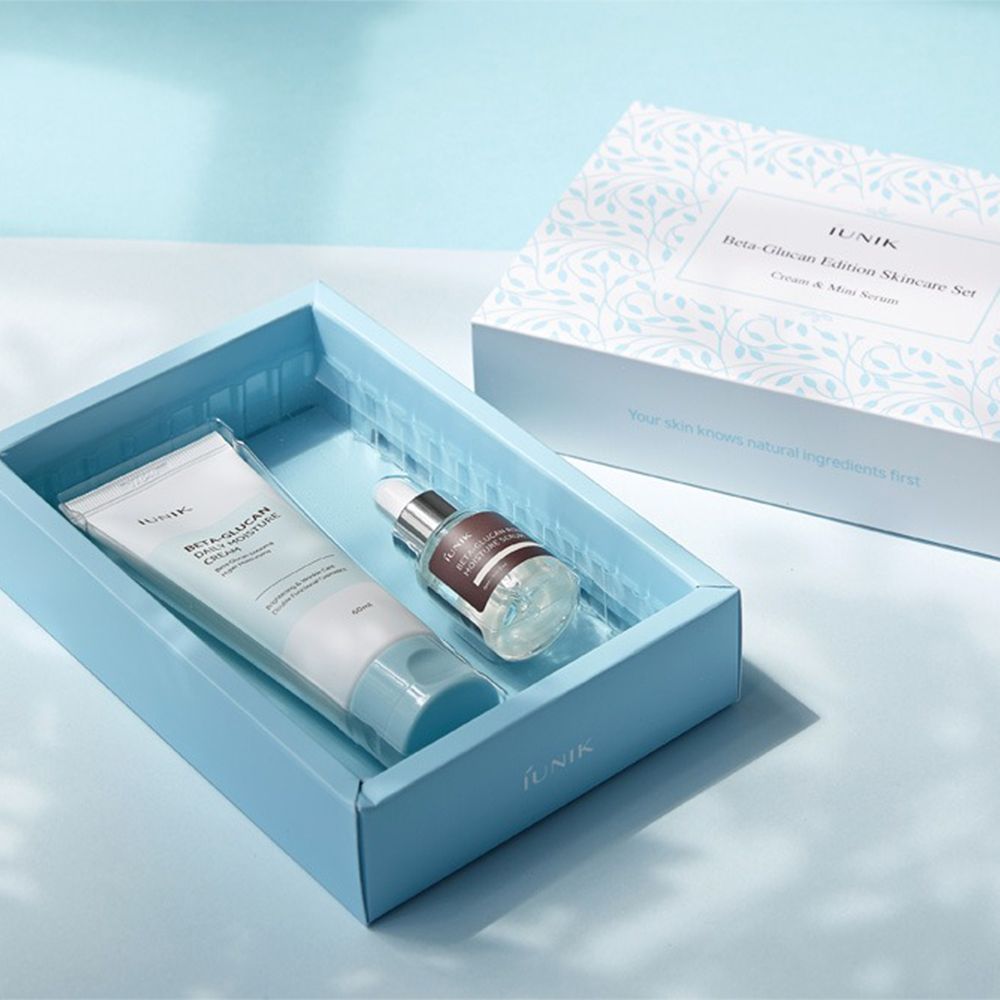 Set skincare iUNIK Beta-Glucan: Crema e siero in una scatola blu, accanto alla confezione del prodotto.
