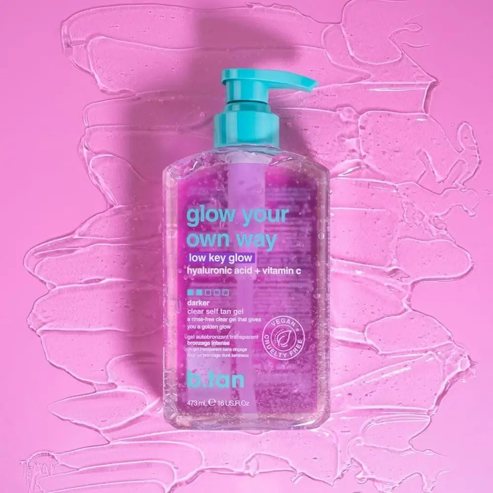 Flacone trasparente con liquido rosa e pompetta blu. Scritta: glow your own way low key glow. Vegano.