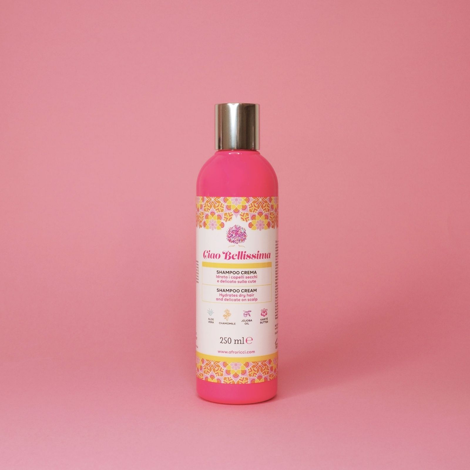 Flacone rosa con tappo argentato. Scritta: Ciao Bellissima, Shampoo Crema. Decorazioni gialle e rosa. 250 ml.