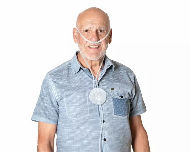 Un uomo anziano indossa occhiali per ossigeno con un serbatoio.