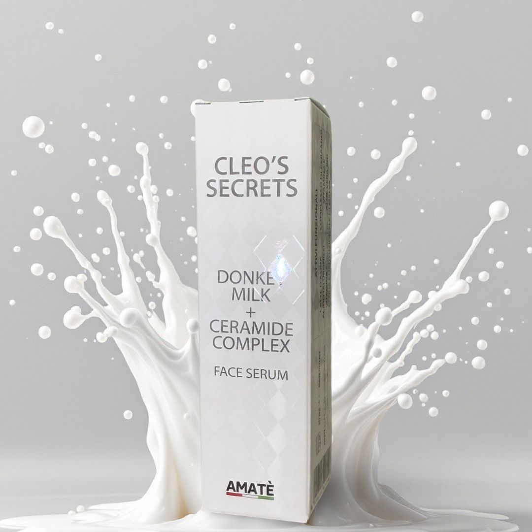 Confezione di siero viso Cleo's Secrets con latte d'asina e ceramidi, circondata da schizzi di latte.