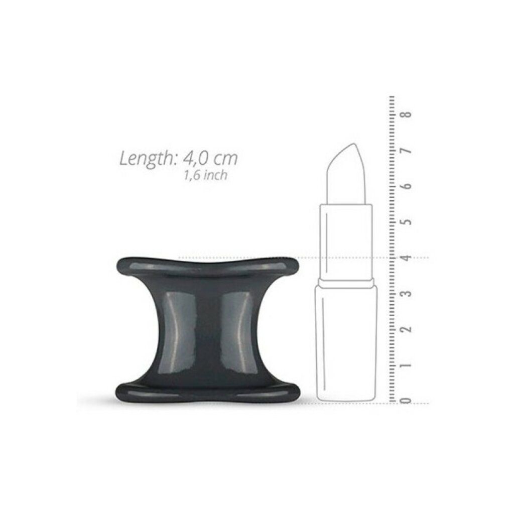 Allargatore per testicoli in silicone grigio scuro accanto a un rossetto. Lunghezza: 4,0 cm, 1,6 pollici. Forma: clessidra. Materiale: silicone.