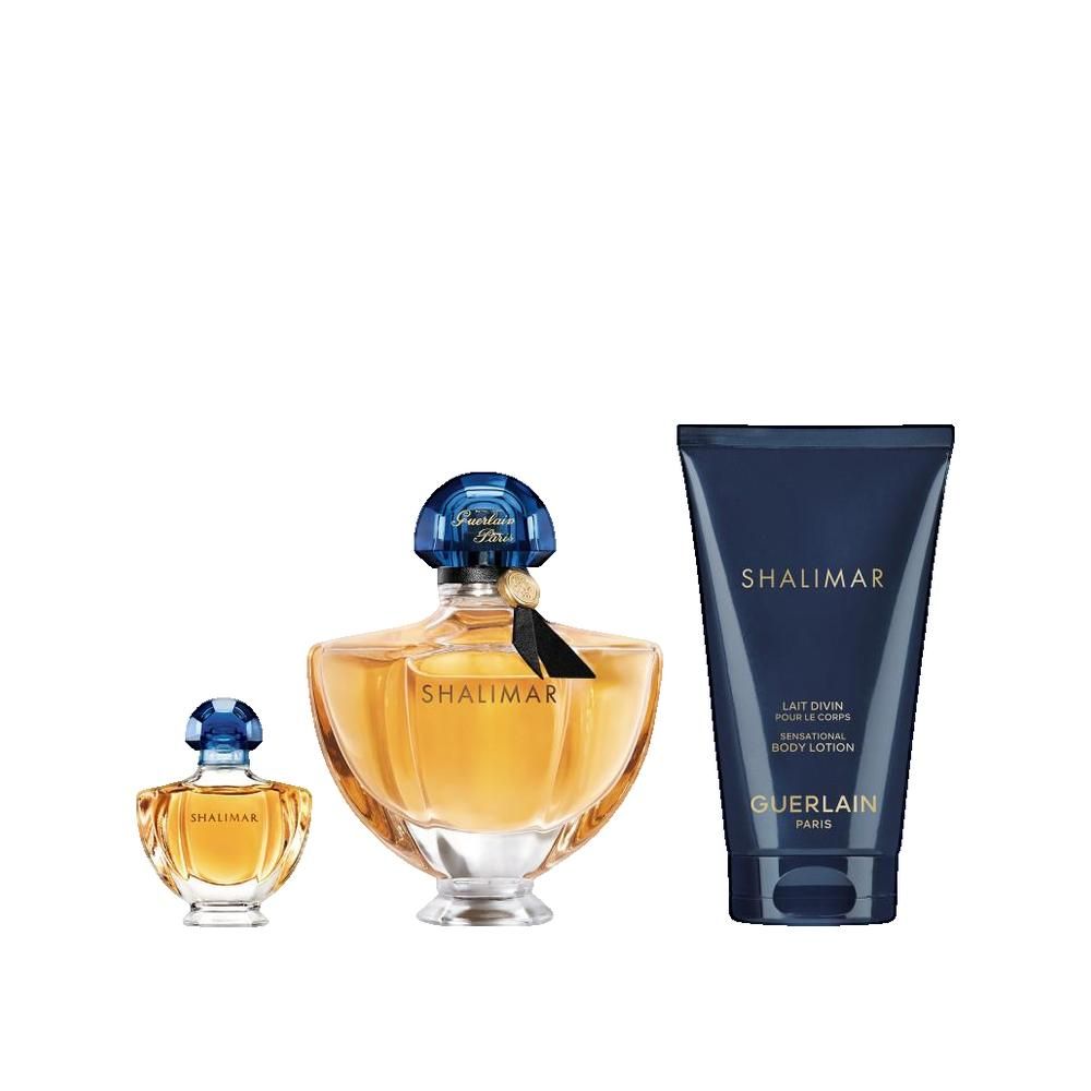 Tre flaconi e un tubetto. Flaconi rotondi, ambrati, con tappi blu. Tubetto blu scuro, testo bianco. Scritta: SHALIMAR, GUERLAIN.
