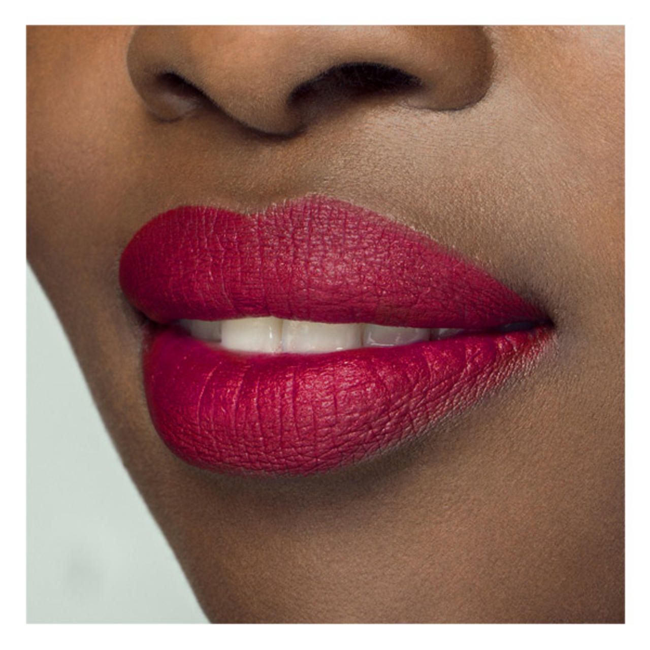 Primo piano di labbra con SISLEY PHYTO LIP TWIST MAT 17. Rosso intenso e opaco. Labbra aperte, denti visibili.