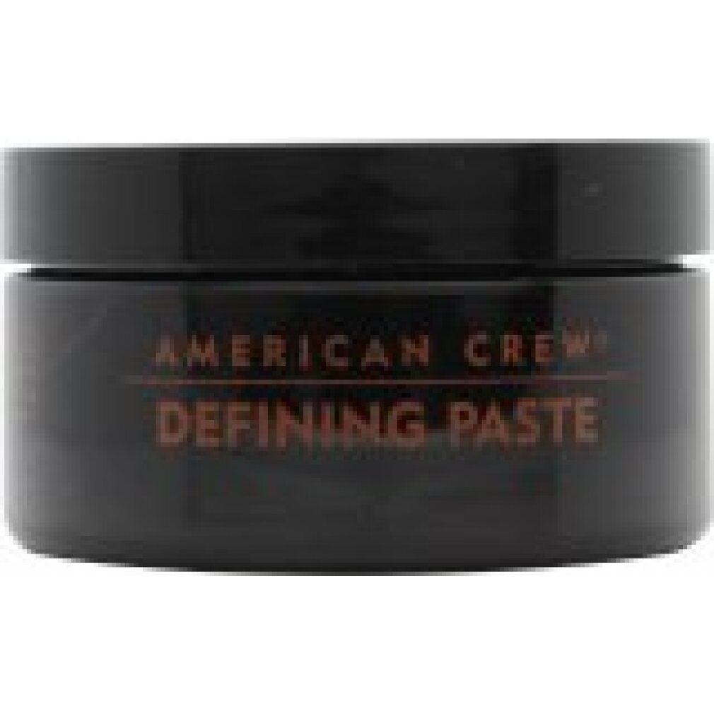 Barattolo rotondo nero con coperchio rosso. Testo: "American Crew Defining Paste".