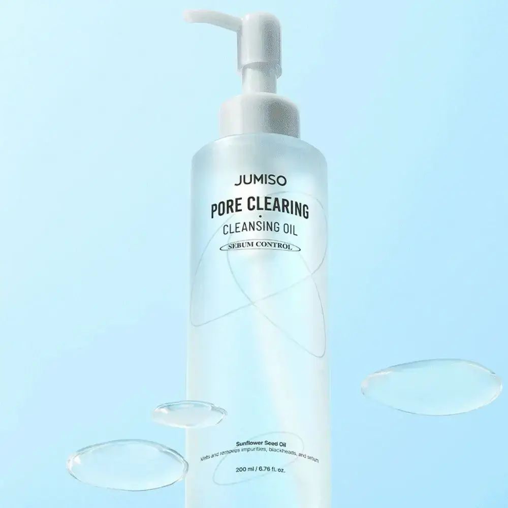 Flacone trasparente con dosatore. Scritta: JUMISO PORE CLEARING CLEANSING OIL. Gocce d'acqua.