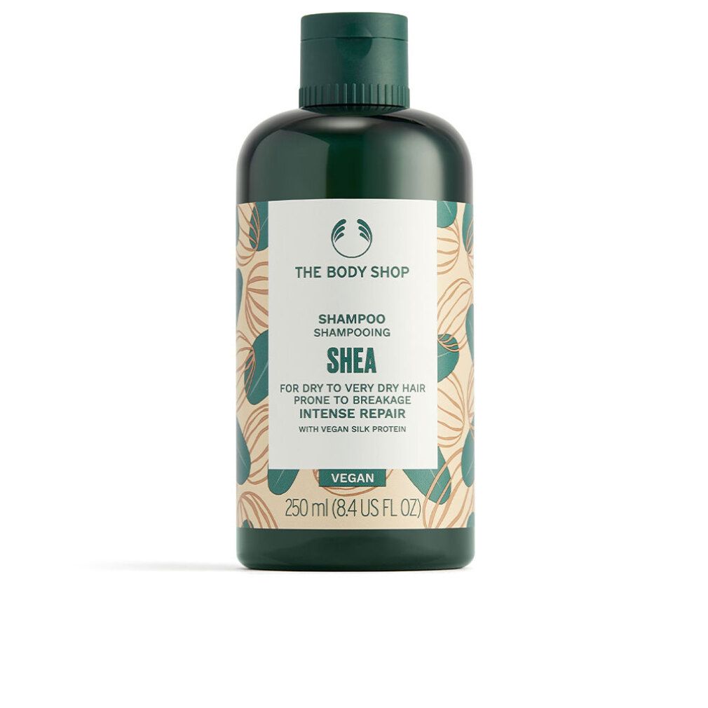 Flacone di shampoo verde con etichetta. Scritta: Shea, The Body Shop, Vegan. Per capelli secchi. 250 ml.