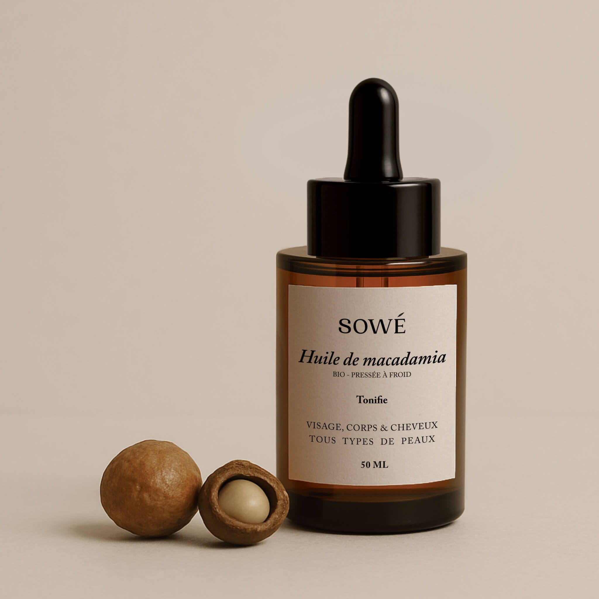 Flacone di vetro marrone con contagocce e due noci di macadamia. Etichetta "SOWÉ".