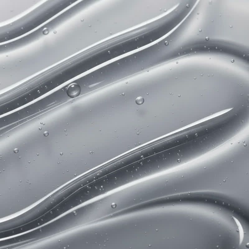 Liquido trasparente ondulato con piccole bolle. Superficie liscia e riflettente. Sfondo grigio.