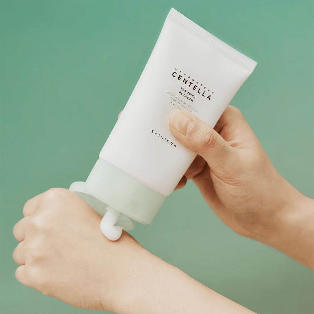Mano che applica la crema dal tubo SKIN1004 Centella Tea-Trica B5 Cream.