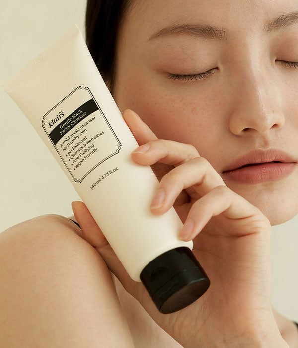Persona che tiene un tubetto. Sul tubetto c'è scritto 'klairs Gentle Black Facial Cleanser'.