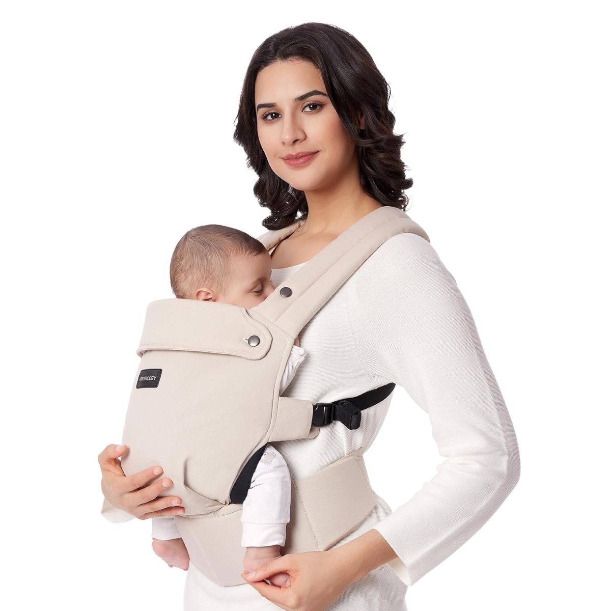 Donna tiene neonato in marsupio beige. Logo Momcozy visibile. Bambino dorme.