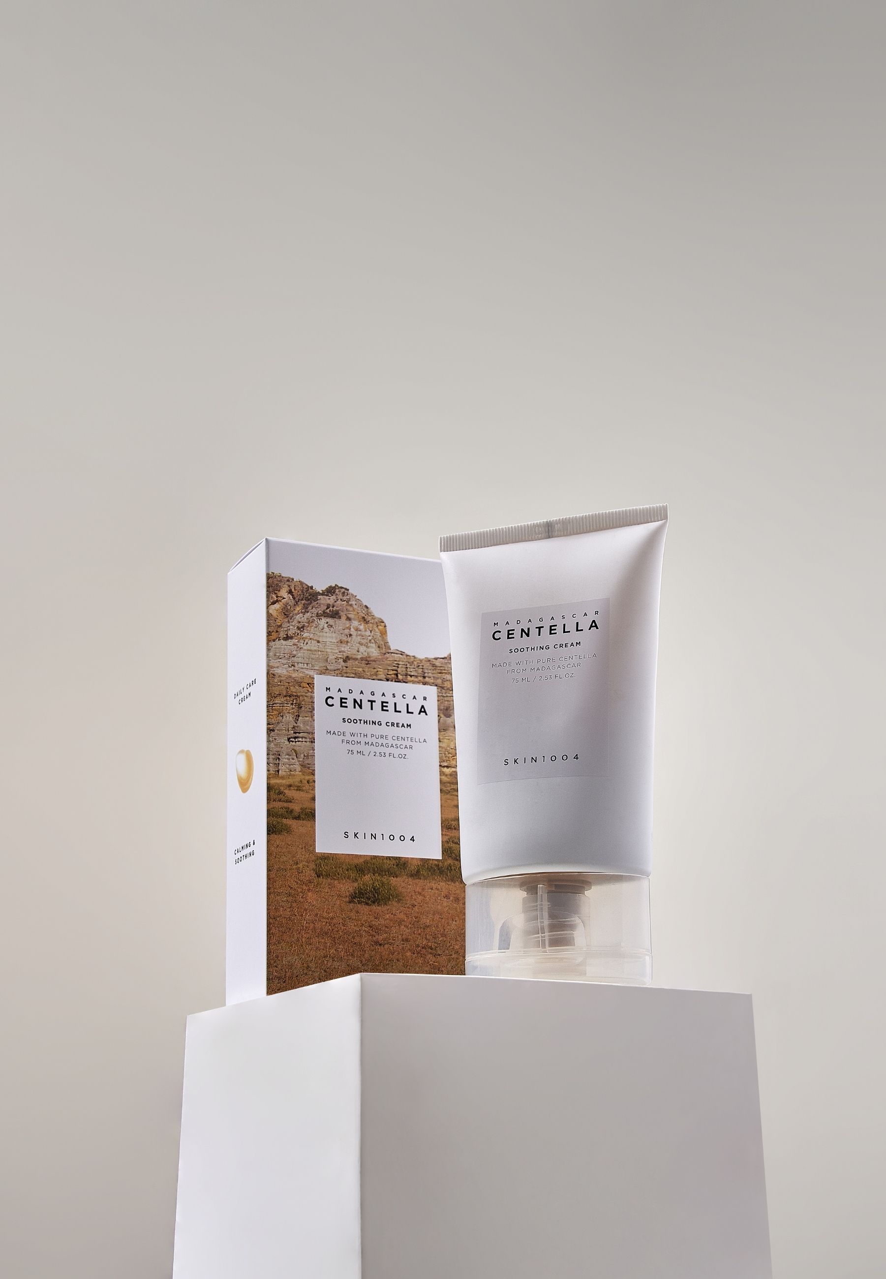 SKIN1004 Madagascar Centella Soothing Cream e confezione su piedistallo bianco. Tubo e scatola affiancati.