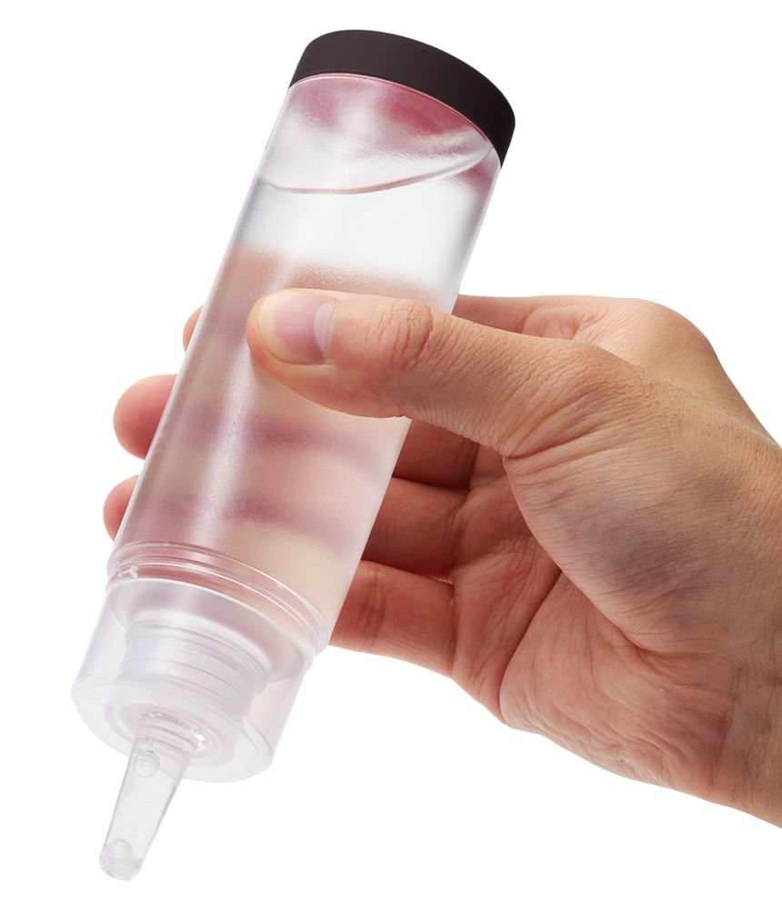 Mano che tiene una bottiglia di Tenga Hole Lotion Light con tappo scuro.