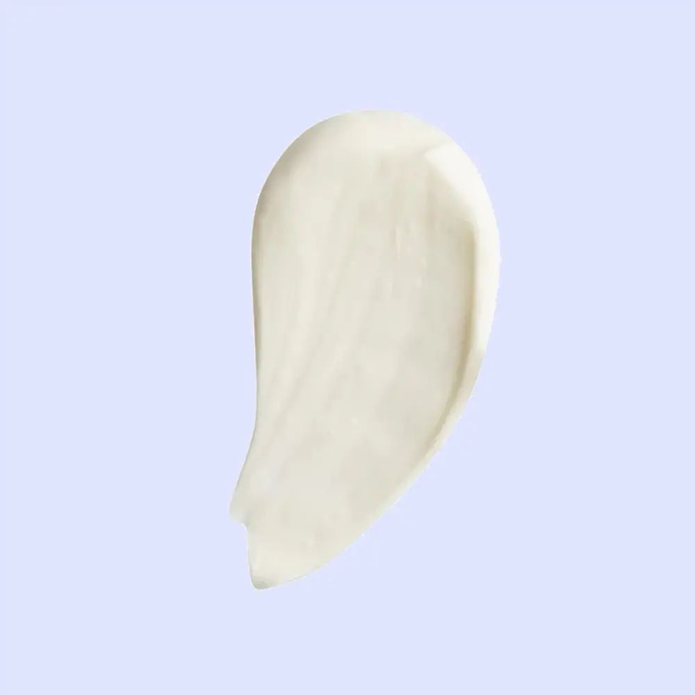 Prodotto cremoso color crema su sfondo azzurro. Forma di goccia curva.