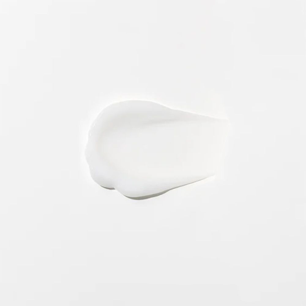 Strato di crema bianca su sfondo chiaro. Consistenza visibile.