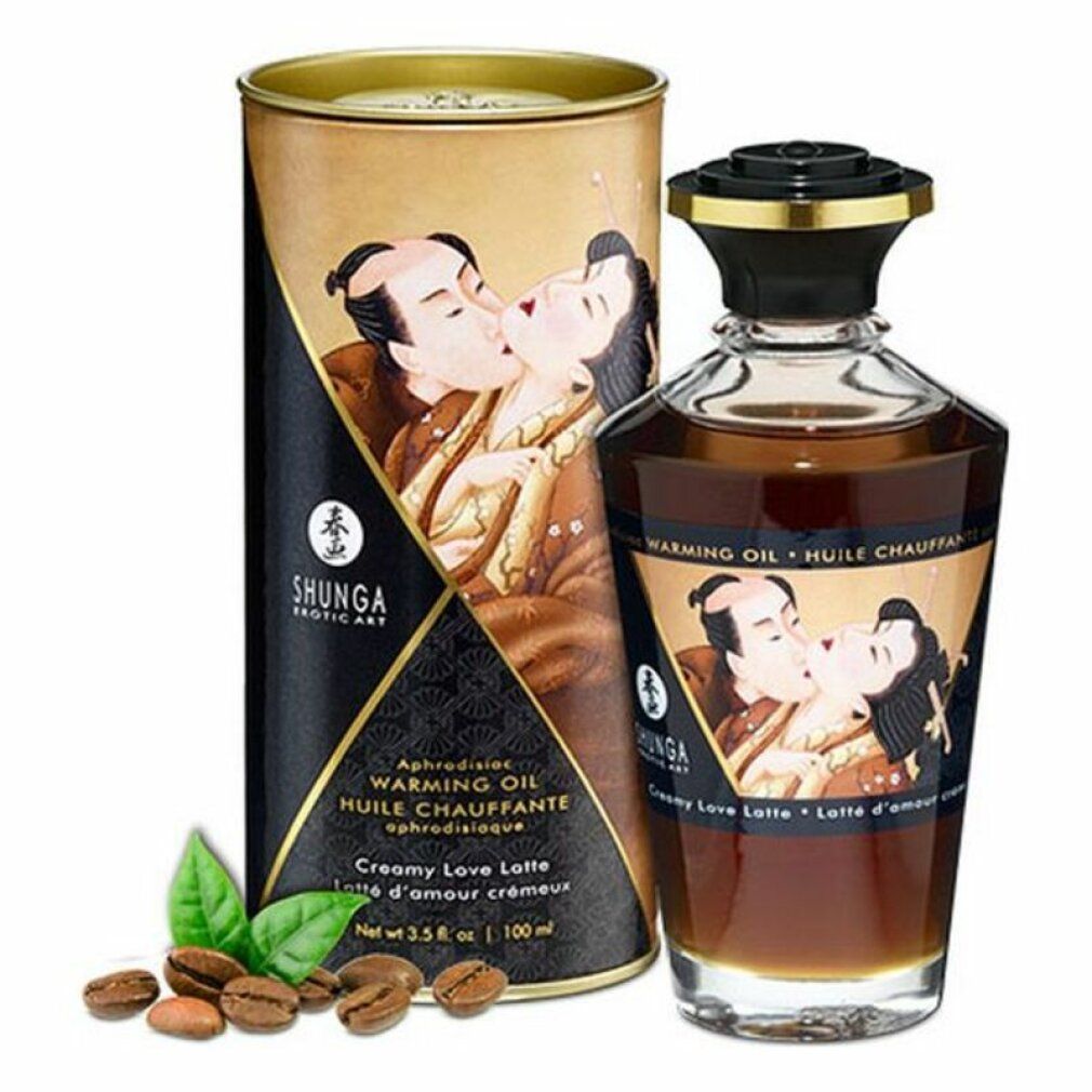 Flacone e scatola con illustrazione. Scritta: Shunga, Warming Oil, Creamy Love Latte. Chicchi di caffè e foglie accanto.