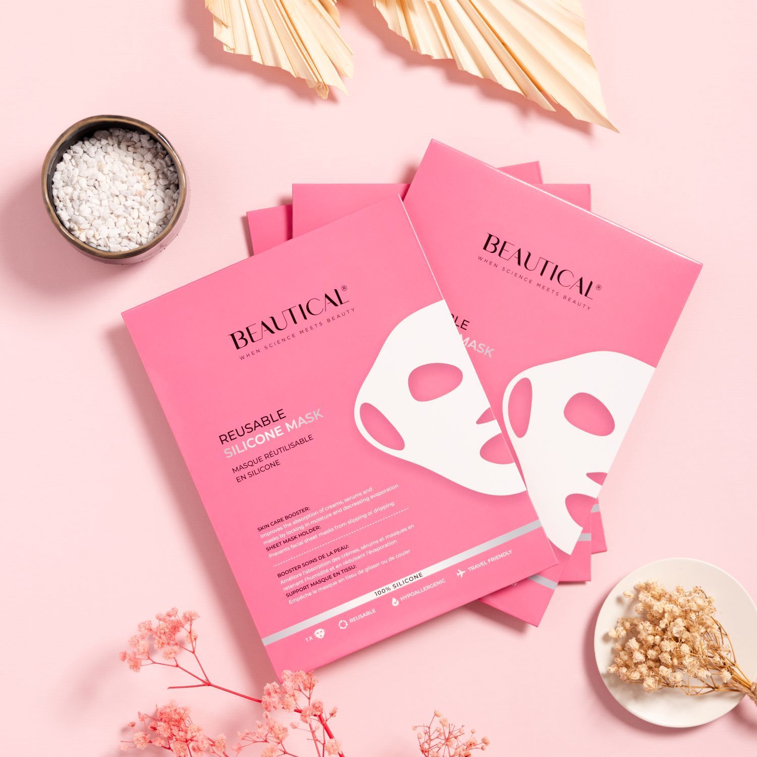 Diverse confezioni rosa con maschere in silicone. Testo: BEAUTICAL, REUSABLE SILICONE MASK. Decorazione: fiori secchi, ciotola.