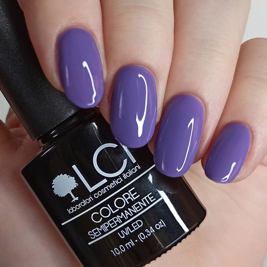 Mani con unghie laccate viola. Flacone con scritta: LCI, Colore Semipermanente, UVLED.