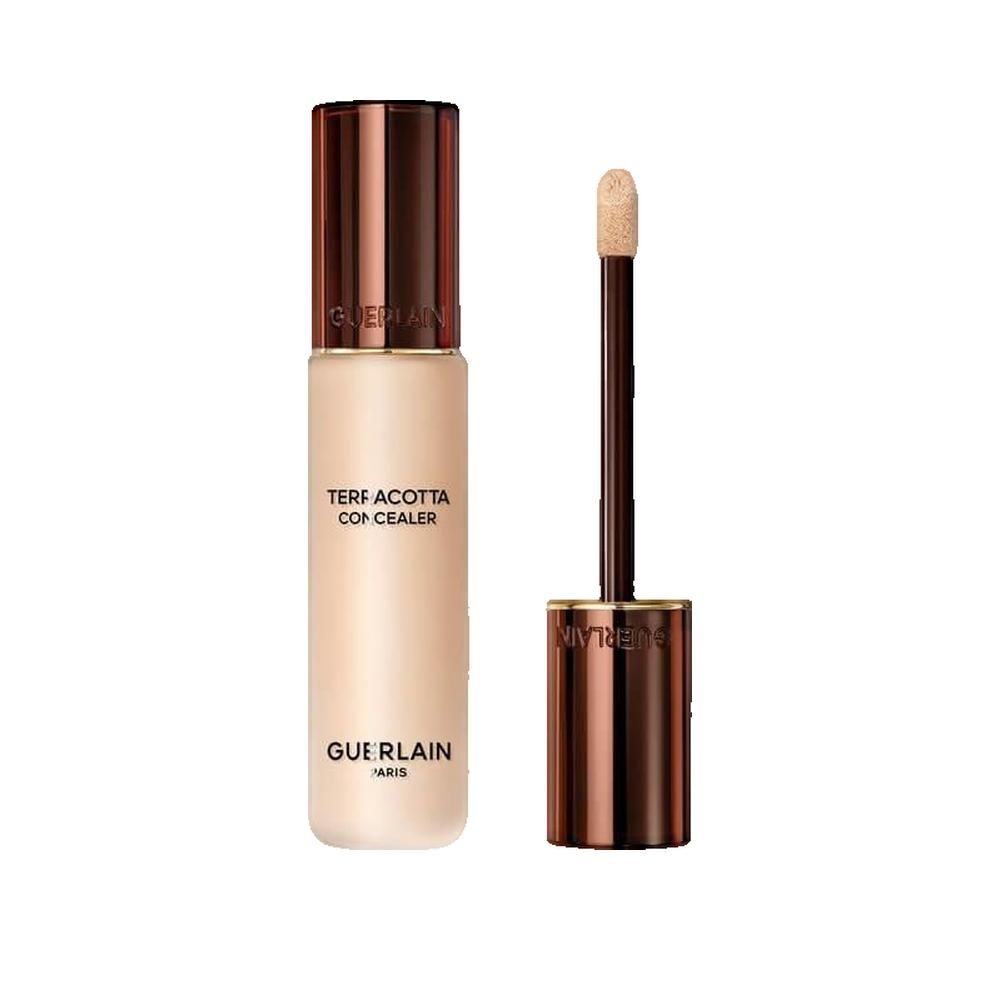 Flacone di correttore beige con tappo e applicatore marrone. Scritta: TERRACOTTA CONCEALER, GUERLAIN PARIS.