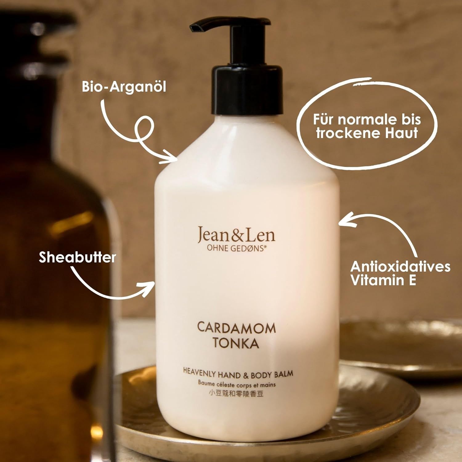 Flacone bianco con dosatore nero. Testo: Cardamom Tonka, Heavenly Hand & Body Balm. Scritta: Per pelli da normali a secche.
