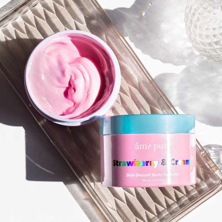 Vasetto rosa con crema rosa. Scritta: âme pure Strawberry & Cream. Su una lastra di vetro.