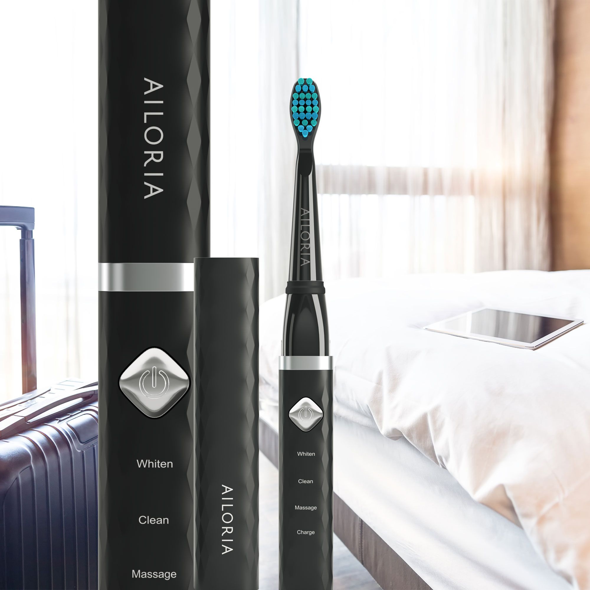 Spazzolino nero con custodia e accessori su un letto. Logo AILORIA. Whiten, Clean, Massage, Charge.