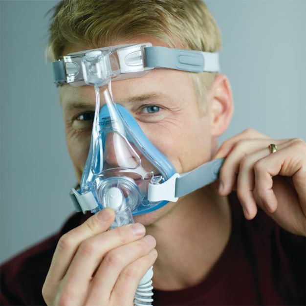Uomo con maschera CPAP Philips Amara SE Gel Full: maschera naso-bocca applicata.