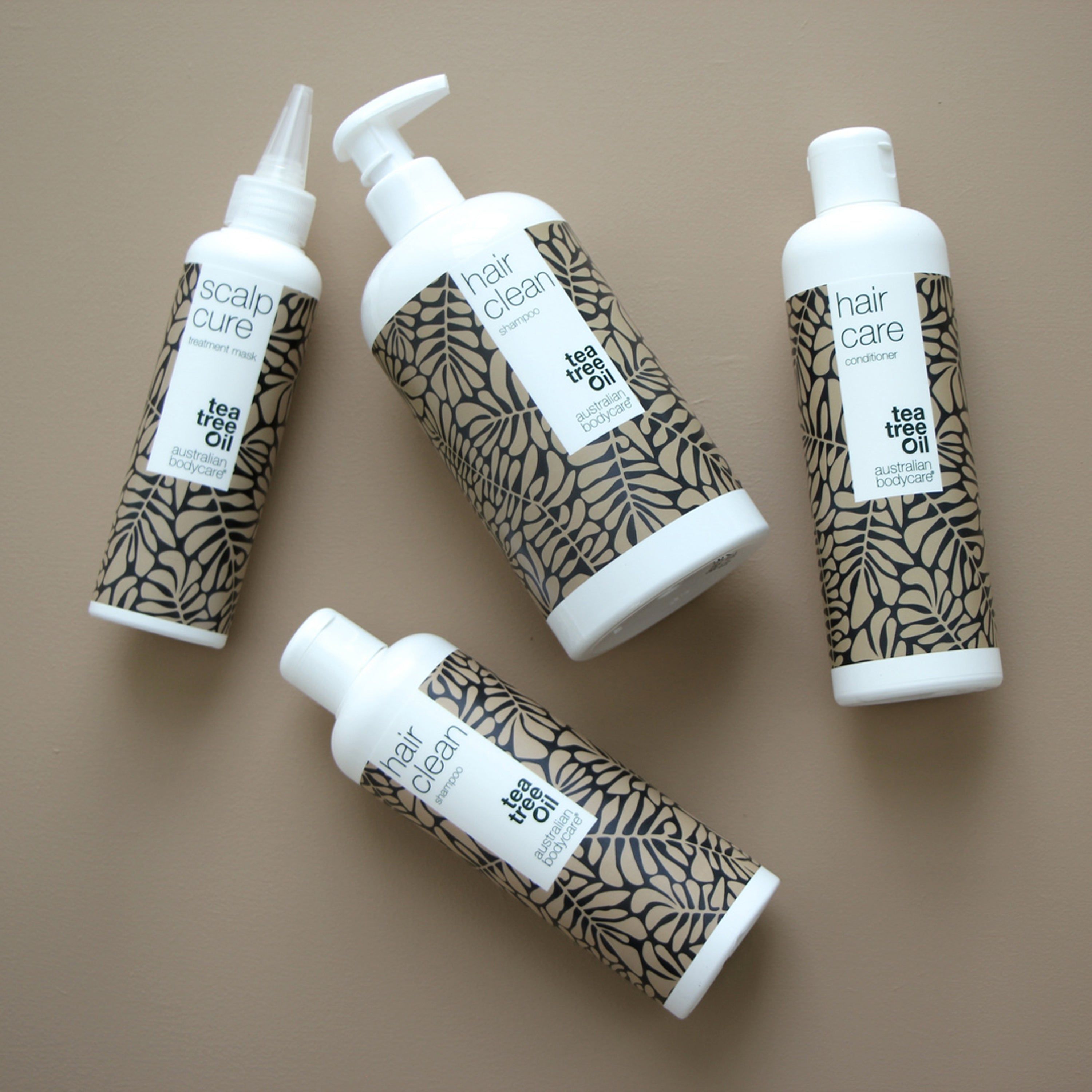 Diversi flaconi e tubetti. Scritta: hair clean shampoo, tea tree Oil, australian bodycare.