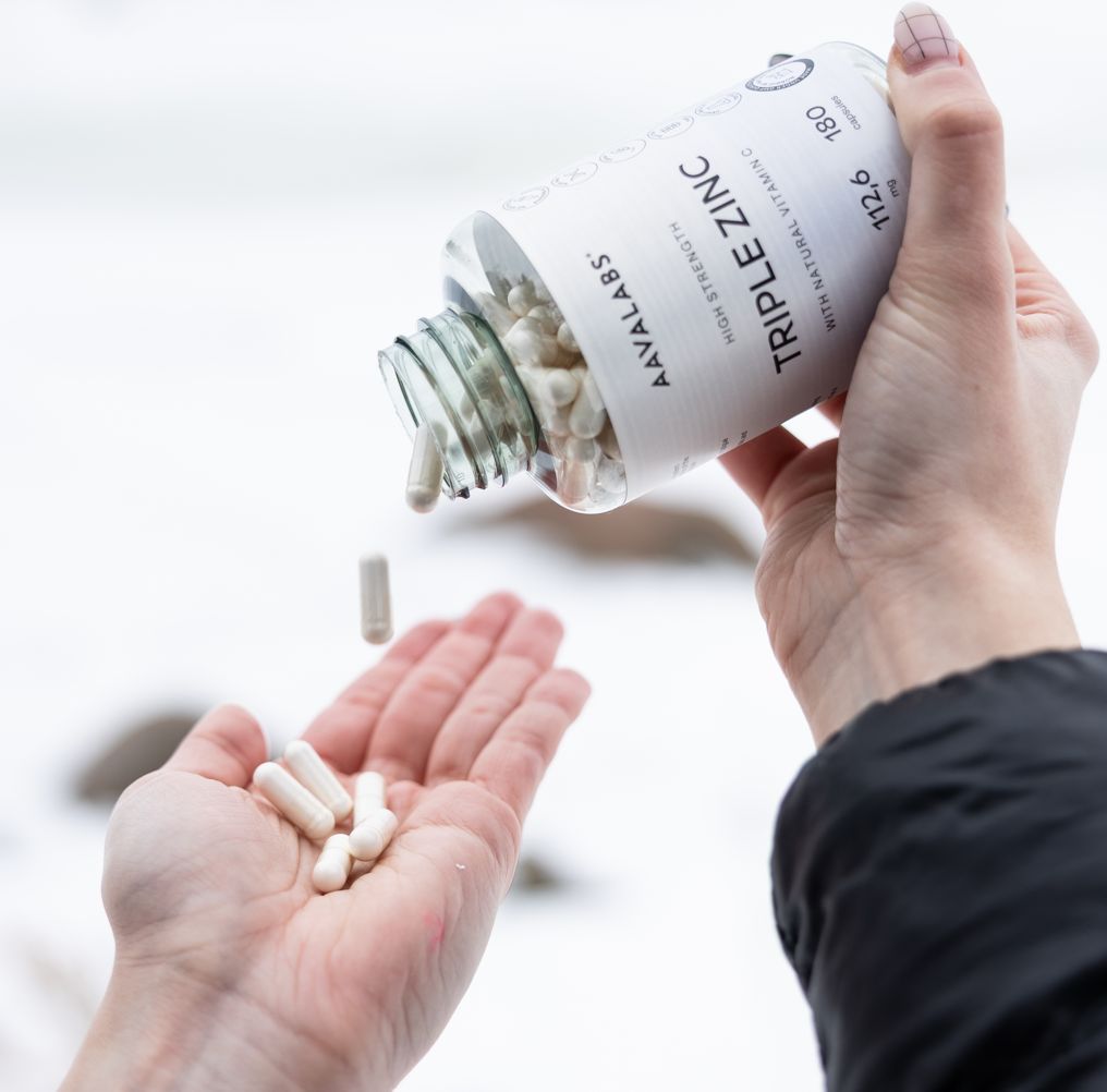 Capsule Aavalabs Triple Zinc versate dalla bottiglia nella mano.