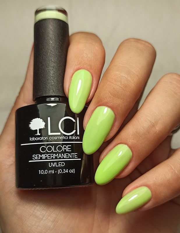 Mano con unghie smaltate e flacone di smalto. Scritta: LCI, Colore Semipermanente, UVLED 10,0 ml.