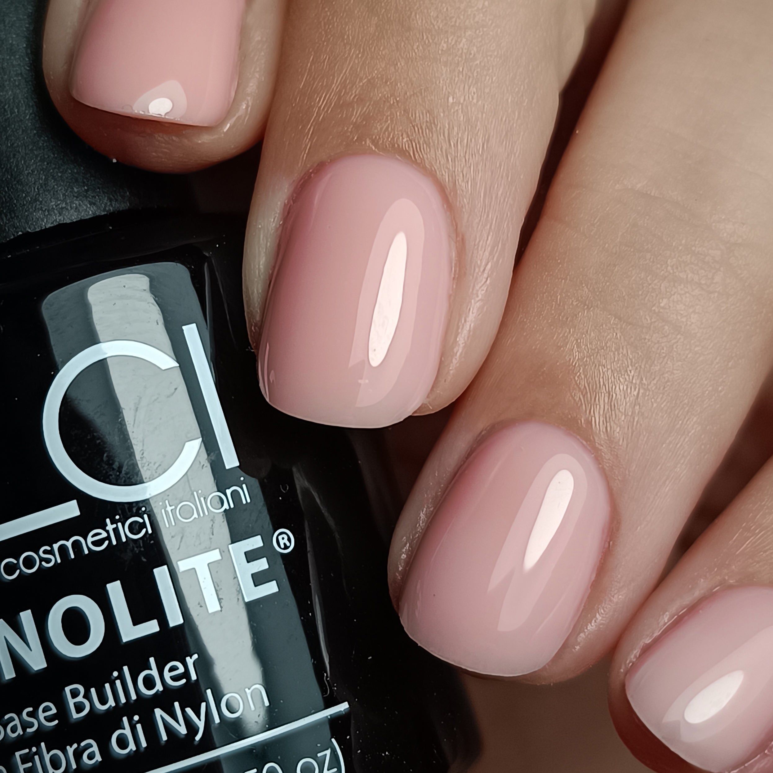 Unghie con LCI Cosmetics MONOLITE Fiber Base, Nude Pink. Smalto rosa sulle dita. Finitura lucida. Primo piano.