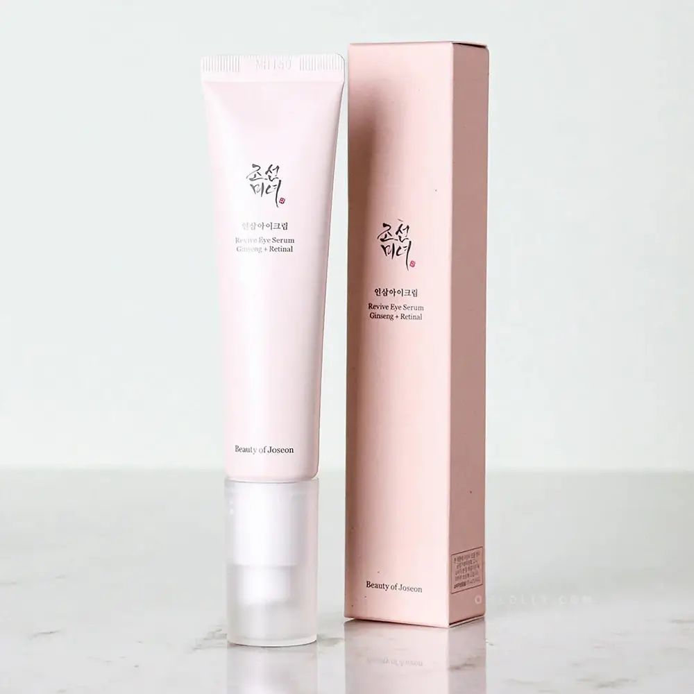 Tubo di crema e scatola. Tubo rosa chiaro con tappo bianco. Scritta: Revive Eye Serum Ginseng + Retinal.
