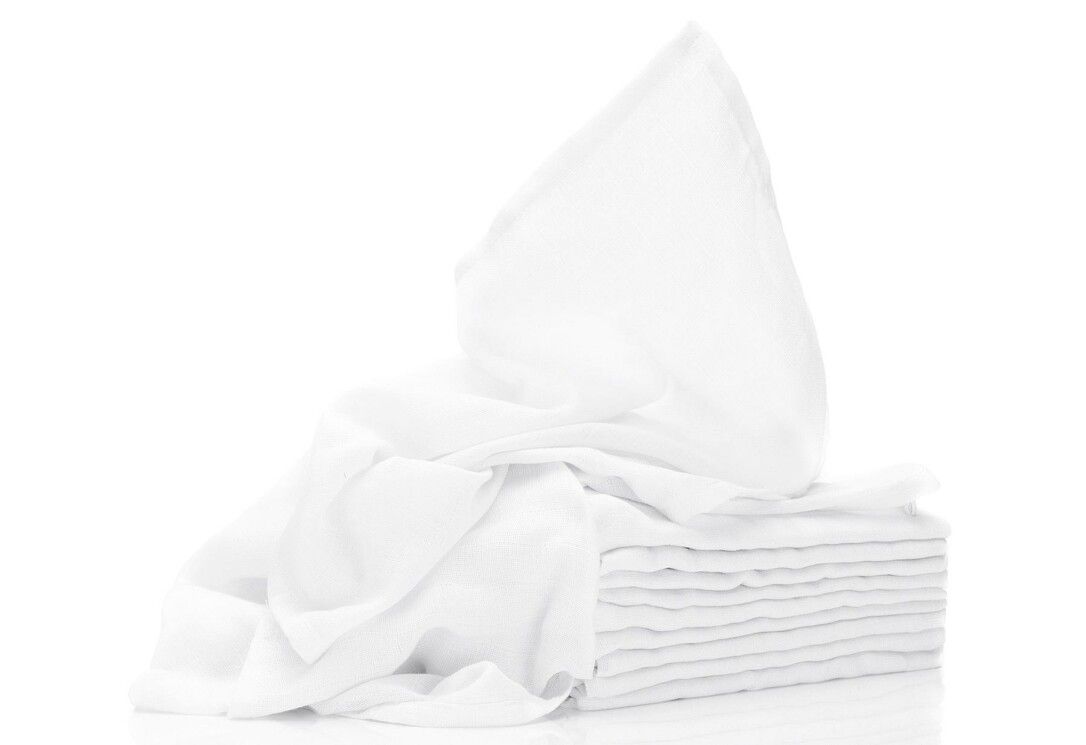 Pila di garze bianche, una parzialmente estratta. Forma quadrata, materiale morbido.