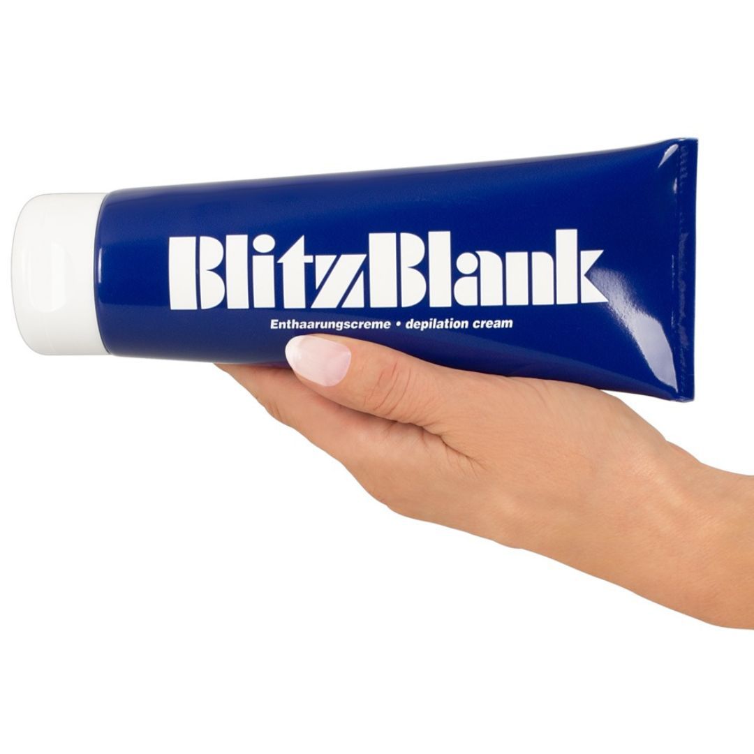 Mano che tiene un tubo blu con scritta bianca BlitzBlank. Contiene crema depilatoria. Chiusura bianca.