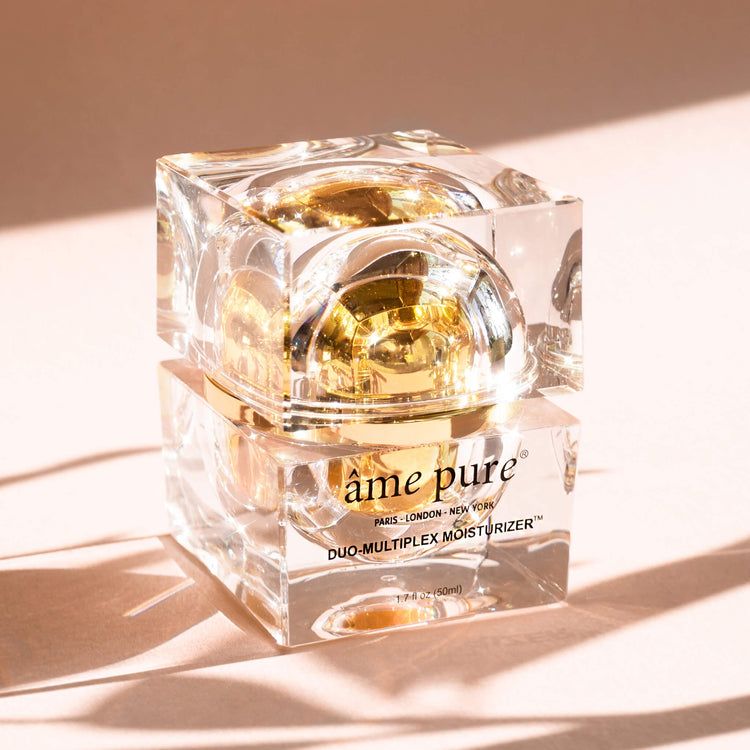 Vasetto trasparente con contenuto e coperchio dorati. Scritta: âme pure DUO-MULTIPLEX MOISTURIZER.