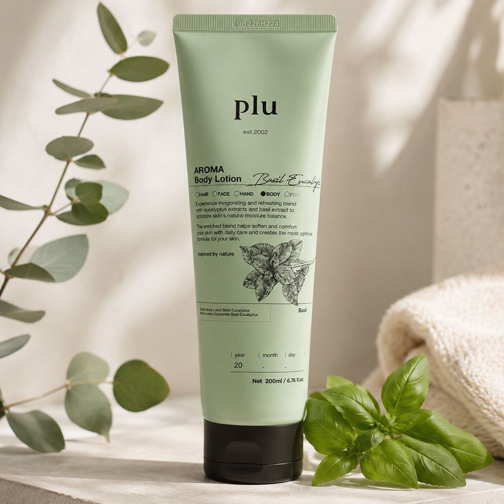 Tubo verde 'plu AROMA Body Lotion Basil Eucalyptus' vicino al basilico e un asciugamano.