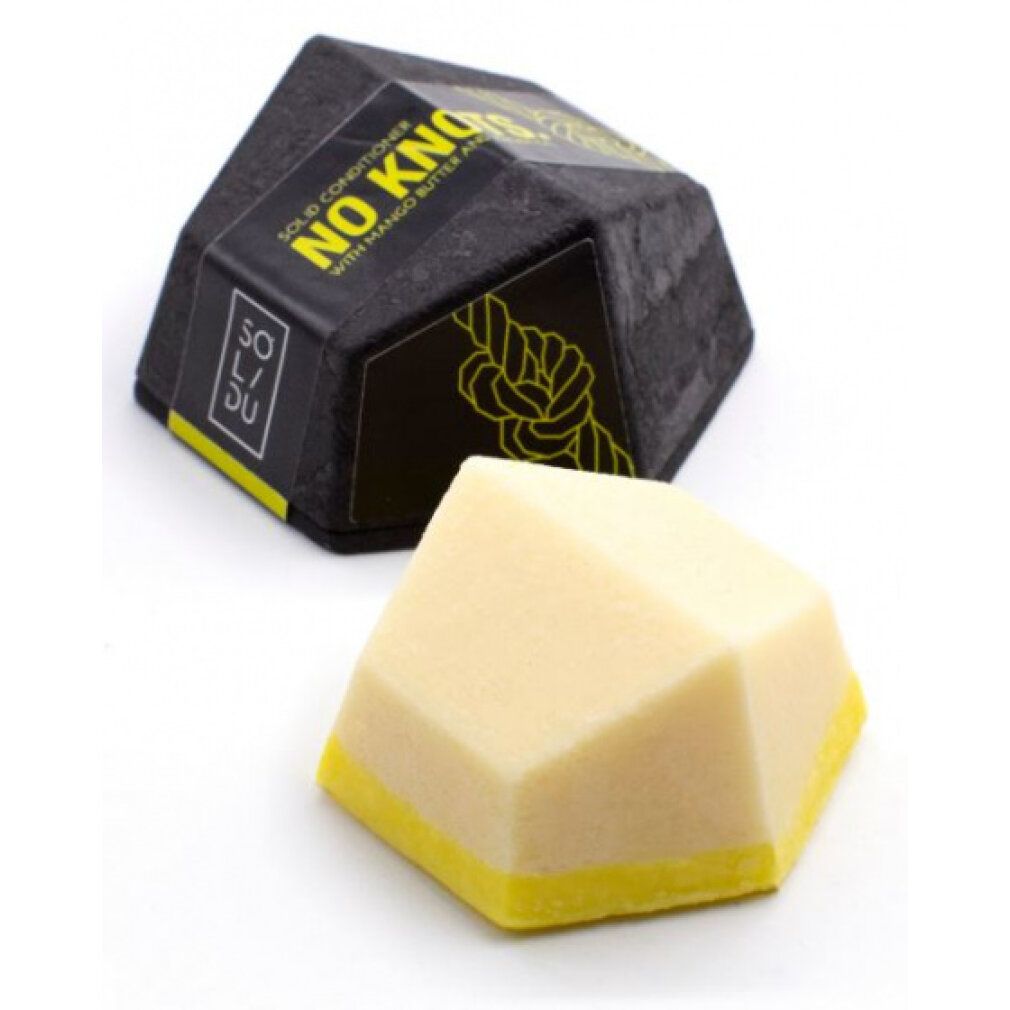 Balsamo solido ottagonale giallo e bianco con bordo giallo, accanto a confezione nera con testo.