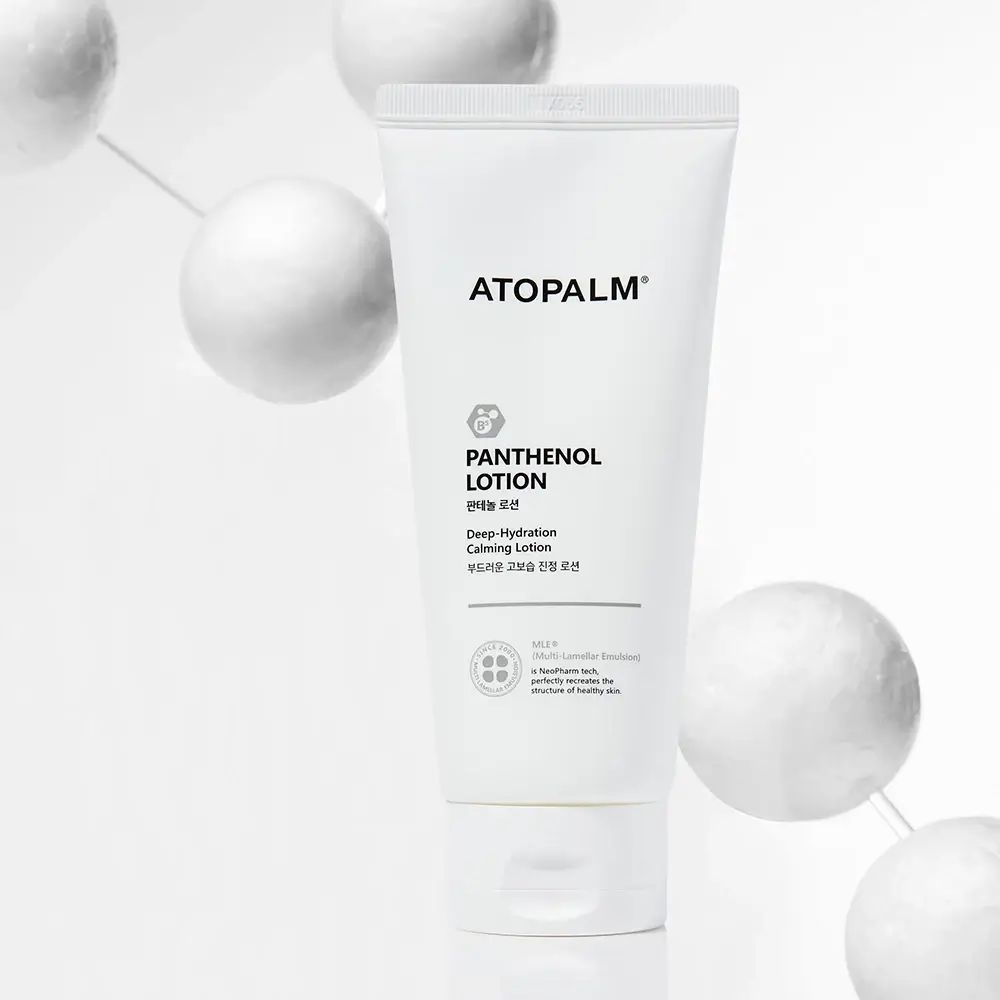 Tubo bianco ATOPALM Panthenol Lotion. Testo: Deep Hydration Calming Lotion. Sfondo: sfere bianche.