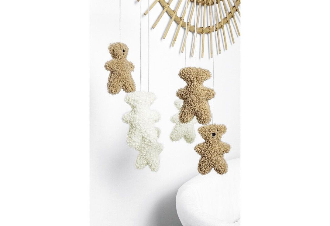 Mobile con orsetti. Due beige, due bianchi e un orsetto marrone chiaro. Sospeso a un anello di bambù.