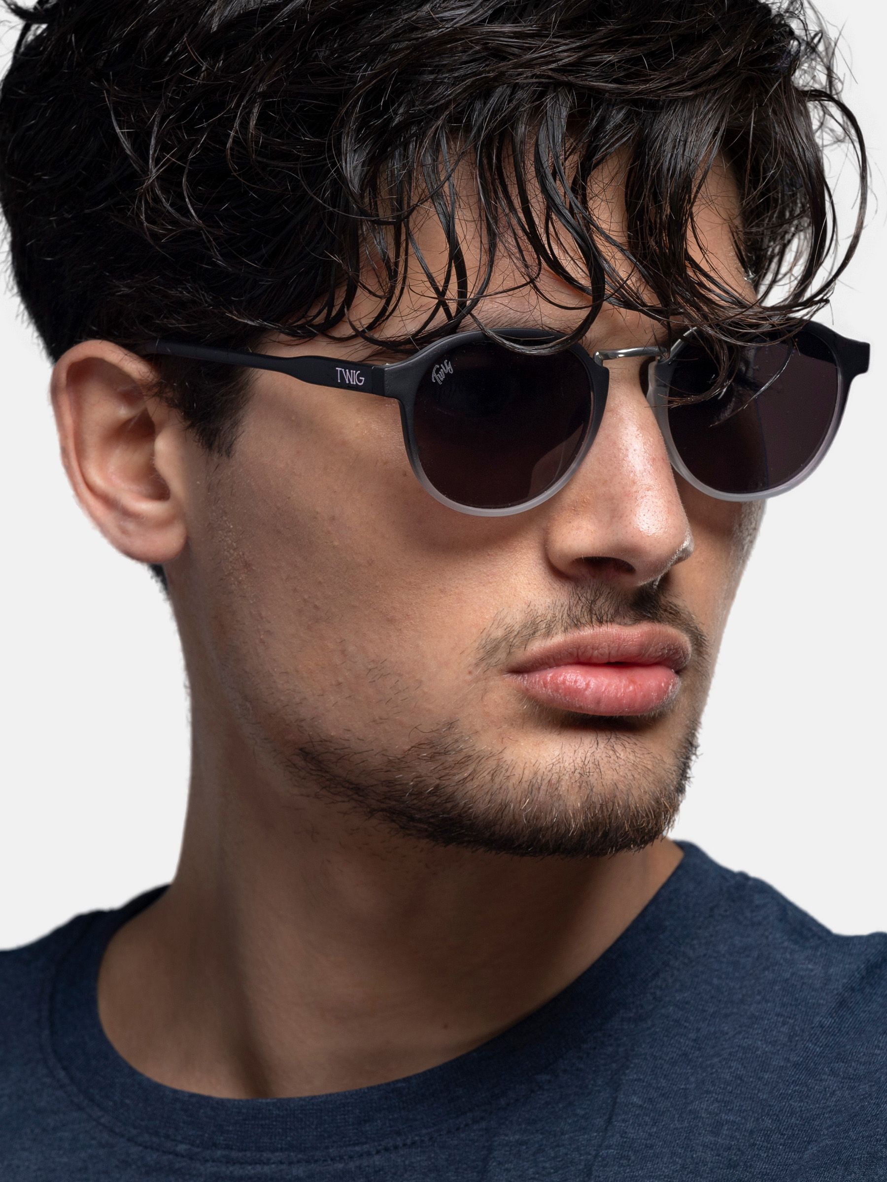 Uomo con occhiali da sole neri. Logo Twig sulla stanghetta. Primo piano.