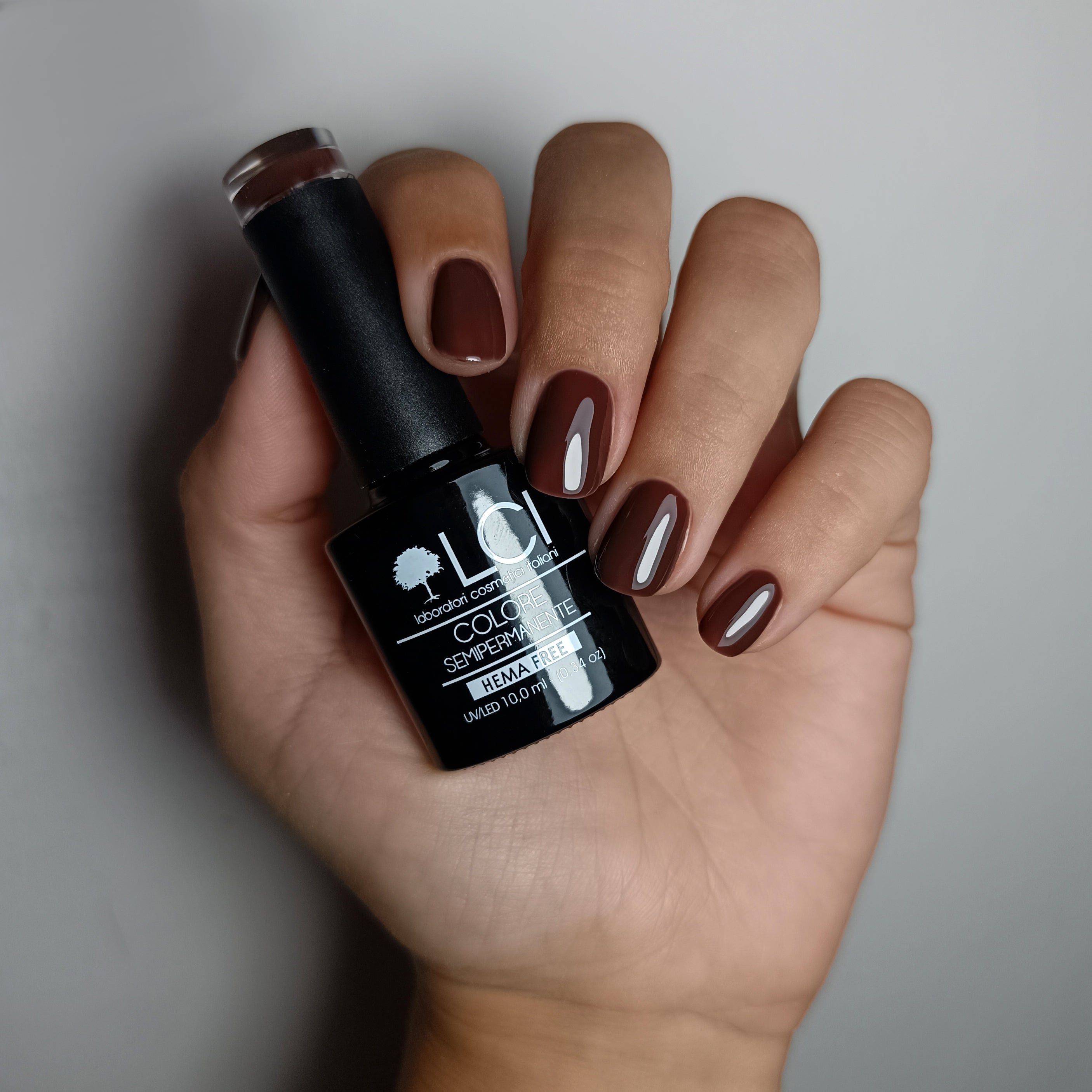 Smalti per unghie marrone scuro in flacone nero con etichetta bianca. "LCI COLOR", "SEMI-PERMANENT", "HEMA FREE" e "10.0 ml" sono leggibili.