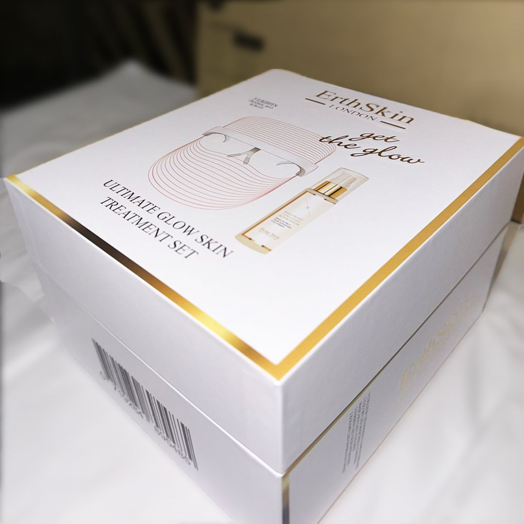 Confezione del set. Bianca con dettagli dorati. Scritta: 'Ultimate Glow Skin Treatment Set'. Logo e immagine del prodotto sul fronte.