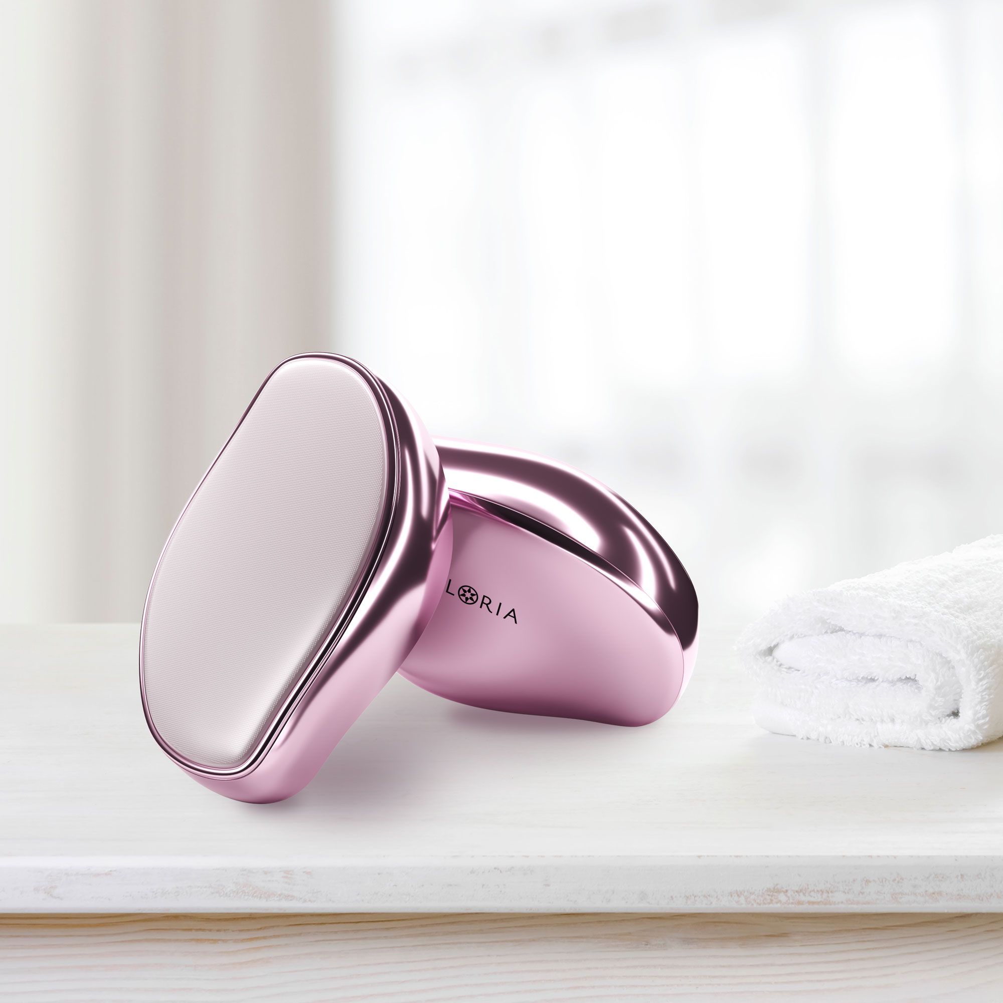 Due rasoi AILORIA GLISSETTE rosa su una superficie. Asciugamano accanto. Logo visibile.