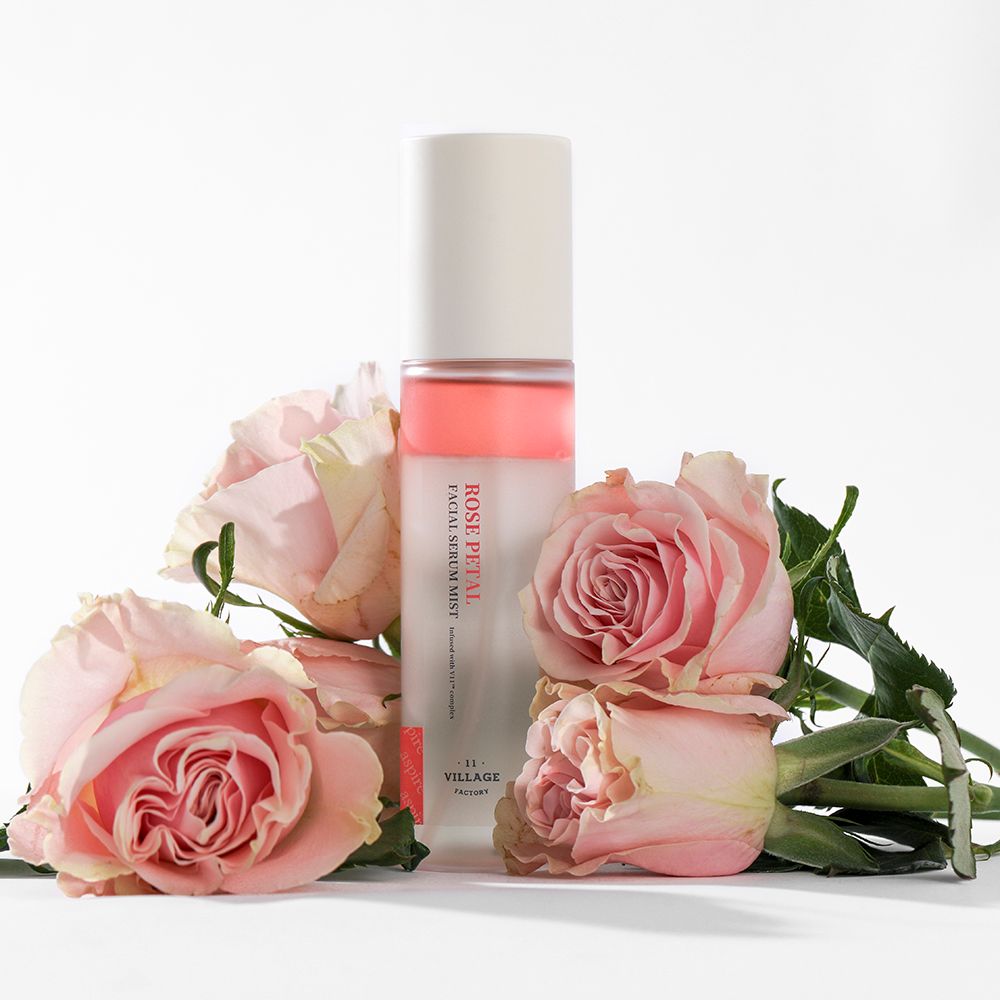 Spray siero viso con rose. Scritta: ROSE PETAL FACIAL SERUM MIST. Circondato da rose.