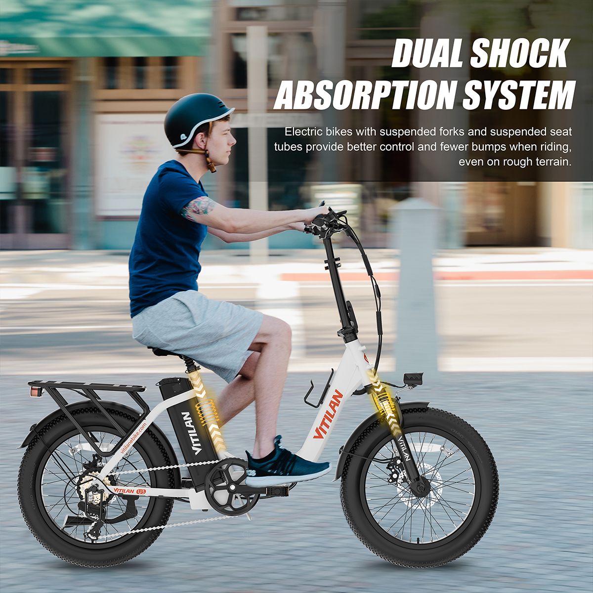 E-bike con doppia sospensione. Ciclista sulla bici. Bici gialla e bianca con portapacchi. Logo VITILAN.