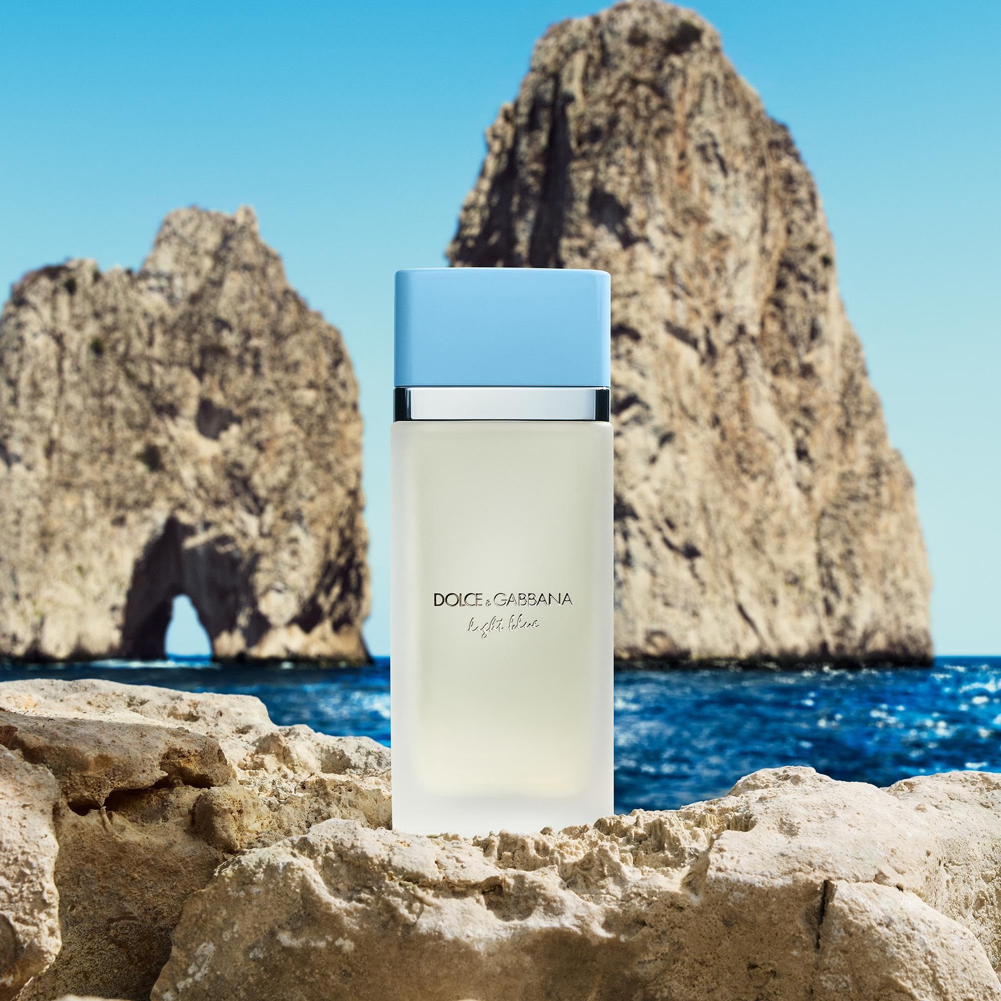 Flacone su pietra. Sfondo: mare e rocce. Scritta: Dolce & Gabbana Light Blue.